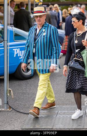 Man in boater hat and striped jacket, Period-dressed spectators walking through the Goodwood Revival event at Goodwood Motor Circuit, West Sussex. Stock Photo