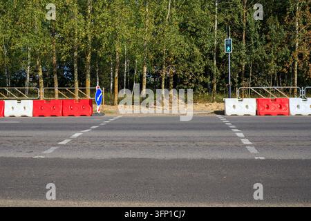 Road Sign 1 Example Only A line of green street barriers blocks a road as people gather farther ...