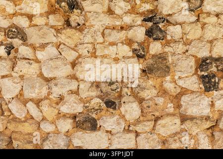 Close-up of the texture of an old medieval wall made of light-coloured stone at the Abbey of Notre Dame de Mortemer in Normandy, France Stock Photo
