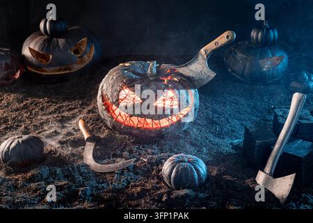 Grinning horror pumpkin with glowing orange inner light. A rusty meat cleaver is stuck in its head. Halloween background for event project. Stock Photo