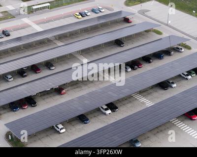 Aerial view of a large parking lot with rows of solar panel canopies providing shade for parked cars in Krakow, Lesser Poland Voivode, Poland. Stock Photo