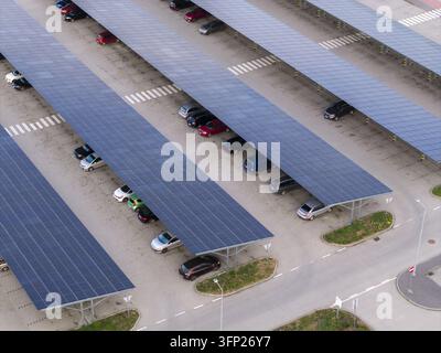 Aerial view of a modern photovoltaic car park with solar panel roofs covering rows of parked cars in Krakow, Lesser Poland Voivode, Poland. Stock Photo