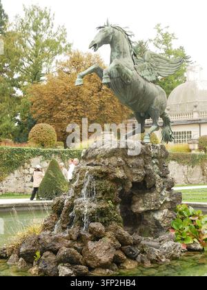 Angled view of the bronze winged Pegasus statue rearing above the stone grotto fountain and cascading water pool in Mirabell Palace Gardens, Salzburg, Stock Photo