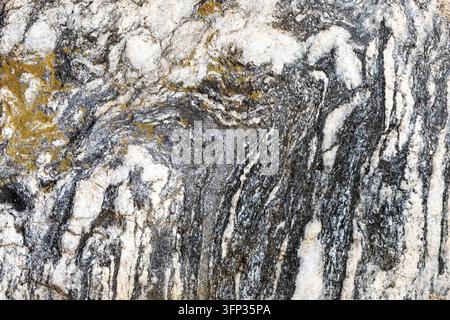 Natural stone with dark, white, and golden grey swirling patterns Stock Photo