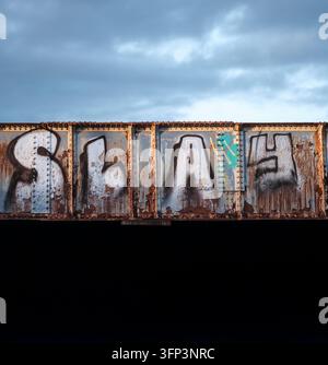 Street Art Graffiti Lettering Saying 'SLAY' Painted On Weathered Steel Girder Of Industrial Railway Bridge Stock Photo