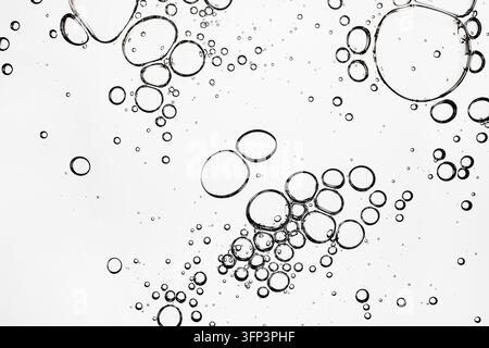 Transparent liquid bubbles creating an abstract pattern on white background Stock Photo