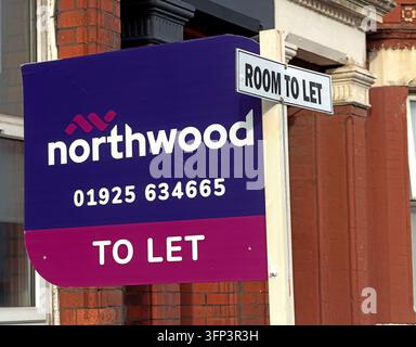 A projecting purple Northwood estate-agent sign advertises ROOM TO LET with a Warrington telephone number outside a brick-built property. Stock Photo