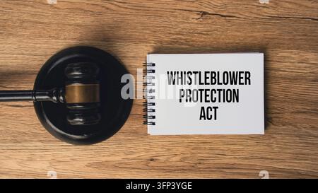 Whistleblower Protection Act text written on notepad beside judge gavel on wooden surface Stock Photo