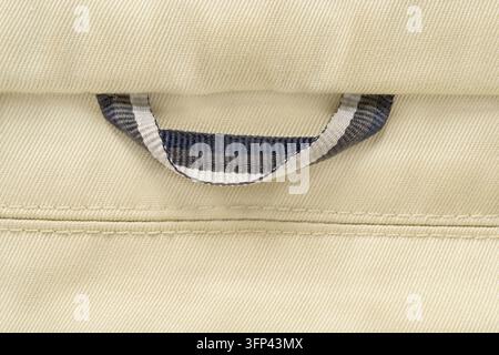 Shirt hanging loop closeup on beige fabric background Stock Photo