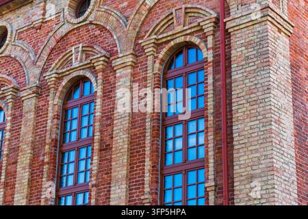 • Close up of arched windows on a historic red brick building facade Stock Photo