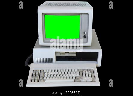 Old generic desktop PC with CRT monitor. Vintage personal computer isolated on black background with chroma key green screen for editing. Stock Photo