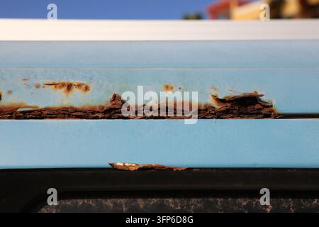 Rusting body in an old blue car. Weather rust damage in vehicle. Stock Photo