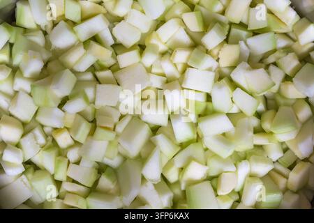 Close-up of diced zucchini cut into small pale green cubes, showing fresh moist flesh and light green skin Stock Photo