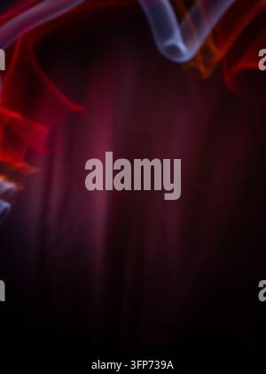 An artistic and abstract composition showing smooth, flowing light trails in shades of red, orange, and white creating a frame against a dark, moody b Stock Photo