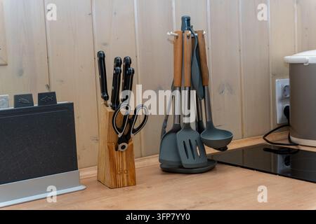 Kitchen countertop with knife block and hanging utensils Stock Photo