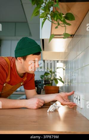 Electrician installing new power sockets in a modern kitchen, focusing on precise connections and home improvements during a renovation project, ensuring safety and functionality Stock Photo