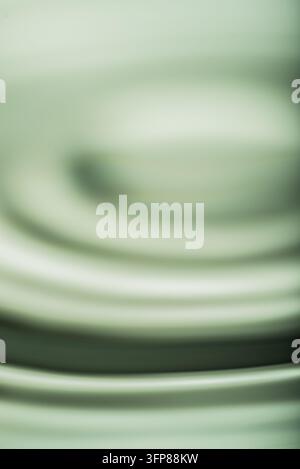 265.Horizontal abstract image captures subtle, dark circular ripples on a calm liquid surface. Soft focus creates a smooth texture and a sense of gent Stock Photo