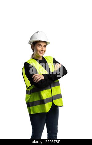 Woman in hard hat and safety vest standing with arms crossed, smiling Stock Photo