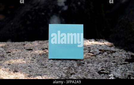 Blue Sticky Note on Dark Stone Background, for reminders, planning, communication, and modern business concepts. Stock Photo