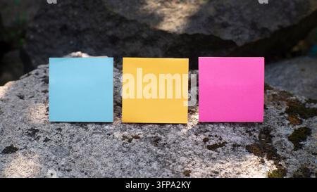 Three Colorful Sticky Notes on Natural Stone Stock Photo
