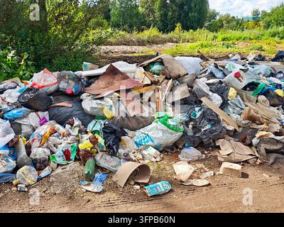 Kirov, Russia - August 19, 2026: Close view of litter and plastic waste left among roadside vegetation, documenting careless disposal, land contaminat Stock Photo