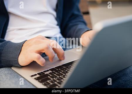 Hands working on laptop outdoors Stock Photo
