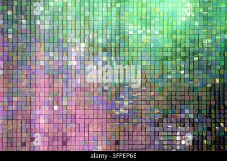 Brightly colored tiles form an intricate mosaic, showcasing a variety of shades including green, purple, and hints of gold. The design creates a dynam Stock Photo