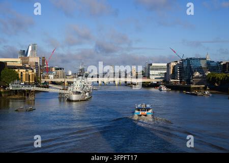 London, UK - September 11, 2026; Thames Clipper Uber boat approaches HMS Belfast on River Thames in morning Stock Photo