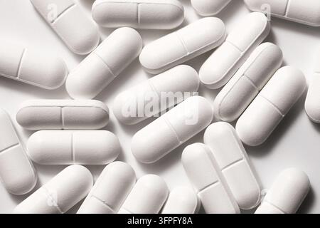 White pharmaceutical capsules in closeup. Medicine background with assorted pills for healthcare pharmacy supplements medication and medical treatment Stock Photo
