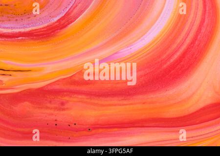 Dynamic abstract background swirling warm orange, bright red, and soft pink fluid paint Stock Photo