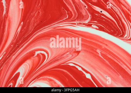 Striking abstract background featuring marbled swirls rich red and clean white fluid paint Stock Photo