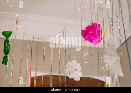 Colorful Christmas party decorations with hanging ribbons and fairy lights Stock Photo
