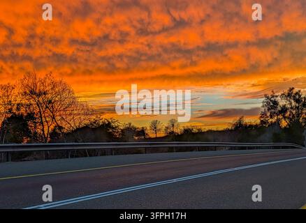 Dramatic glowing sunset turns clouds shade of orange, pink and black Stock Photo