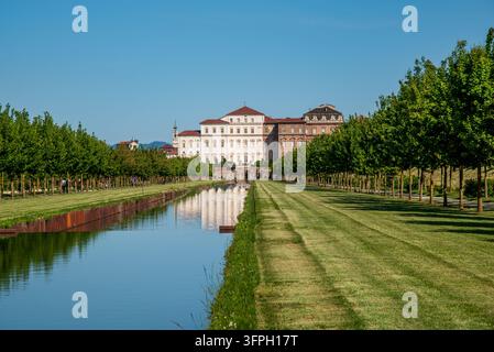 Daytime panoramic shot of the gardens of the Palace of Venaria Reale. The image shows the long central water canal reflecting the historic palace faca Stock Photo