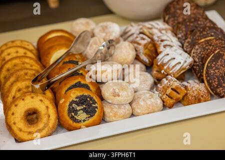 Tray of assorted sweet pastries, including donuts and buns, ready for breakfast or dessert Stock Photo