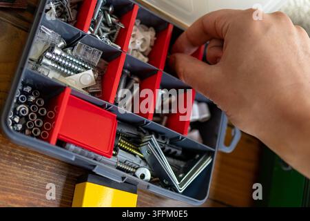 Close up of an open toolbox filled with screws bolts and hardware fasteners for a diy project. The image shows organized tools and materials needed fo Stock Photo