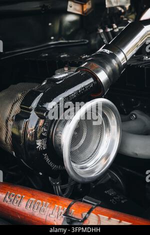 Close-up of a high performance BorgWarner turbocharger installed inside a custom modified hot rod vehicle engine bay. Stock Photo