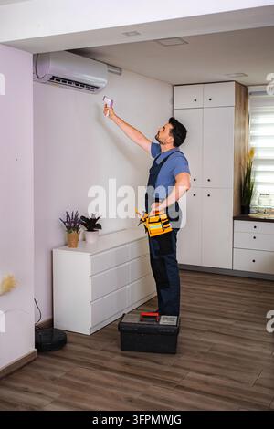Technician checking air conditioner temperature with infrared thermometer Stock Photo