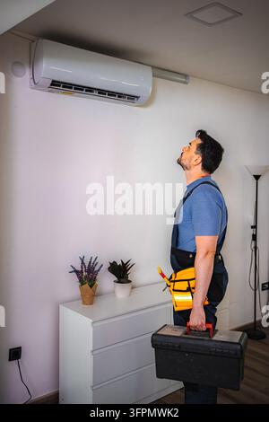 Ac repairman checking air conditioner unit indoors Stock Photo