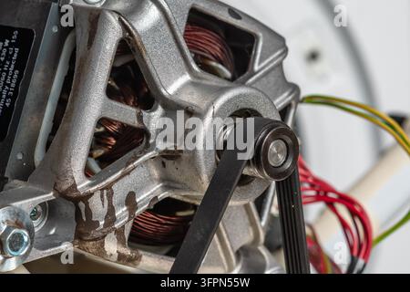 Close-up of washing machine motor with drive belt. Concept of washing machine motor repair. Stock Photo
