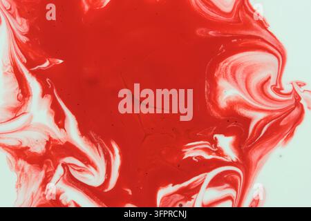 Bright red and white acrylic paint mixing abstract fluid art background with dynamic marble waves Stock Photo