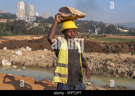 Workers carrying blocks on construction site in Kigali, Rwanda Stock Photo