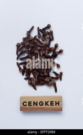 Top view of dried cloves arranged with a wooden label reading "CENGKEH", representing spice, culinary ingredient, agriculture, and Indonesian food Stock Photo