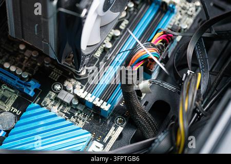 Tashkent, Uzbekistan, September 30, 2026: Close-up view of an Asus motherboard inside a PC case, showing RAM slots, CPU cooling fan, heat sink, power Stock Photo