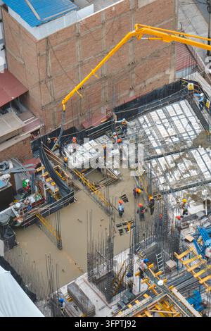 Construction site with workers pouring concrete using a pump in magdalena del mar, lima Stock Photo
