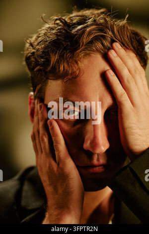 Portrait of Stressed Man Holding Head in Mental Fatigue Stock Photo