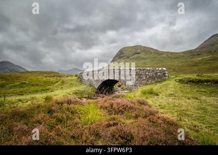 A stone bridge over a stream on the West Highland Way on Rannoch Moor in the highlands of Scotland Stock Photo