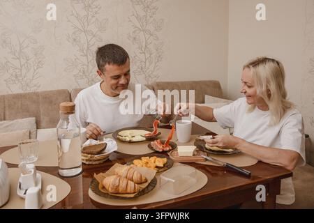 Couple enjoying breakfast together in their home kitchen space Stock Photo
