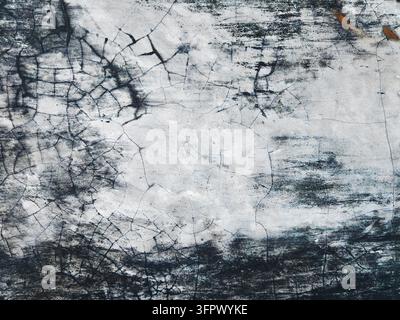 Detailed view of cracked white concrete wall with prominent dark grunge textures on the edges. Stock Photo