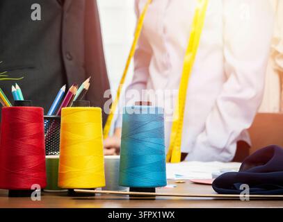 Cropped image of  young Asian female fashion designer is working in her workshop. Stylish young woman in process of creating new clothes collection. Stock Photo